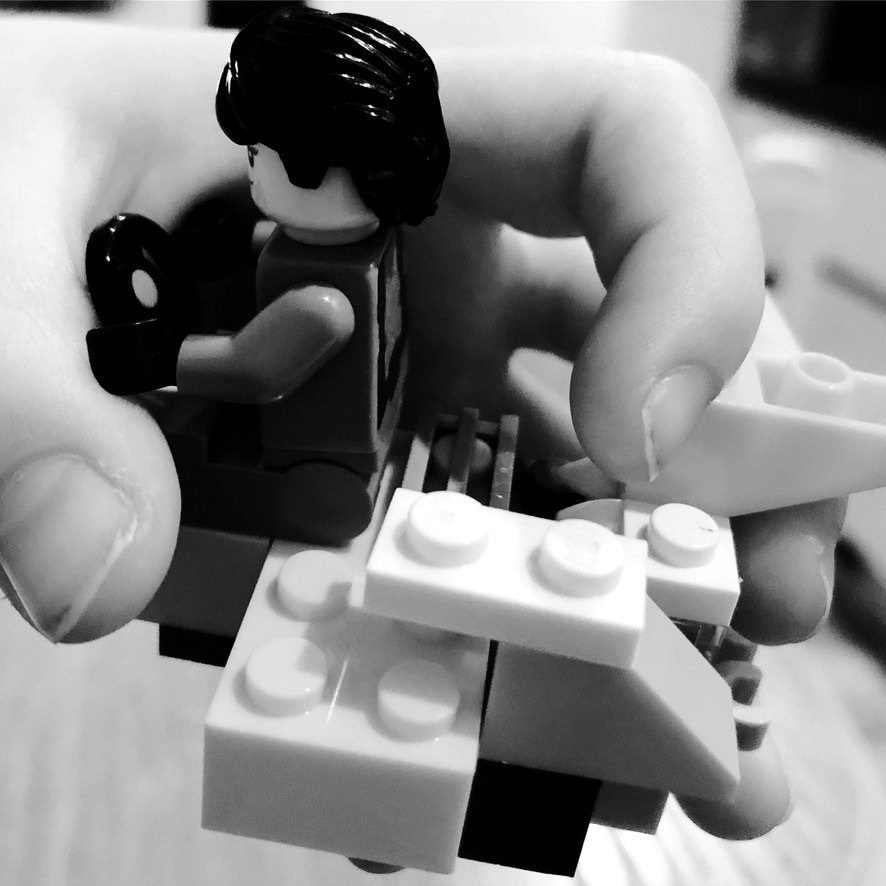 A mão de uma criança a construir com peças de Lego